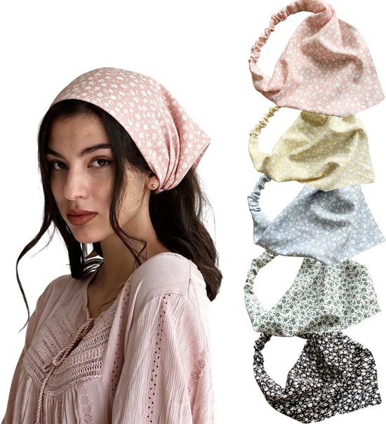 Een vrouw met lang bruin haar draagt een roze bandana met een klein wit bloemenpatroon. De bandana is een haarband met elastische achterkant.