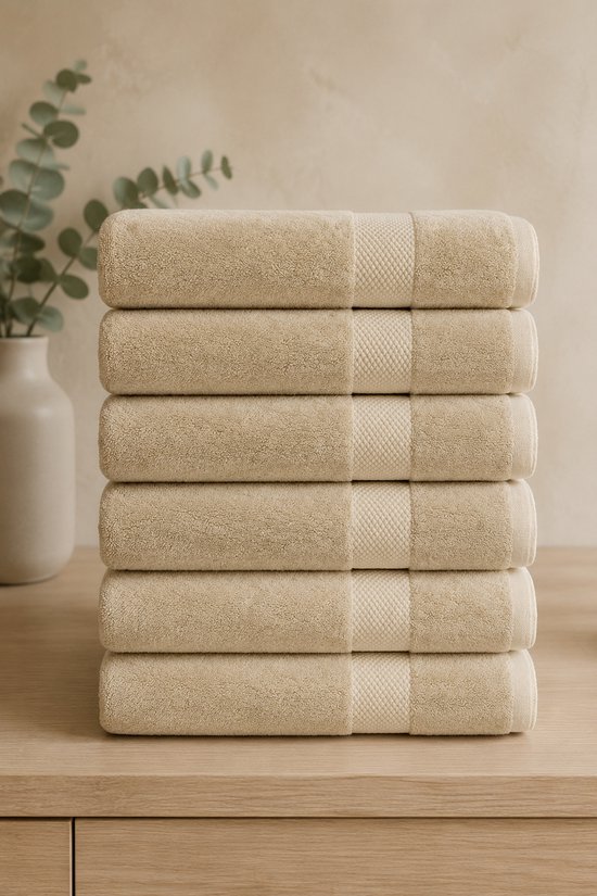Pile de six serviettes beige clair avec un motif à carreaux discret au centre.