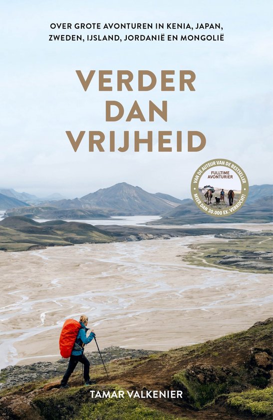 Couverture de livre avec une aventurière portant un sac à dos rouge, debout sur une colline surplombant un paysage désertique avec des montagnes en arrière-plan. Texte : 'Verder dan vrijheid'.