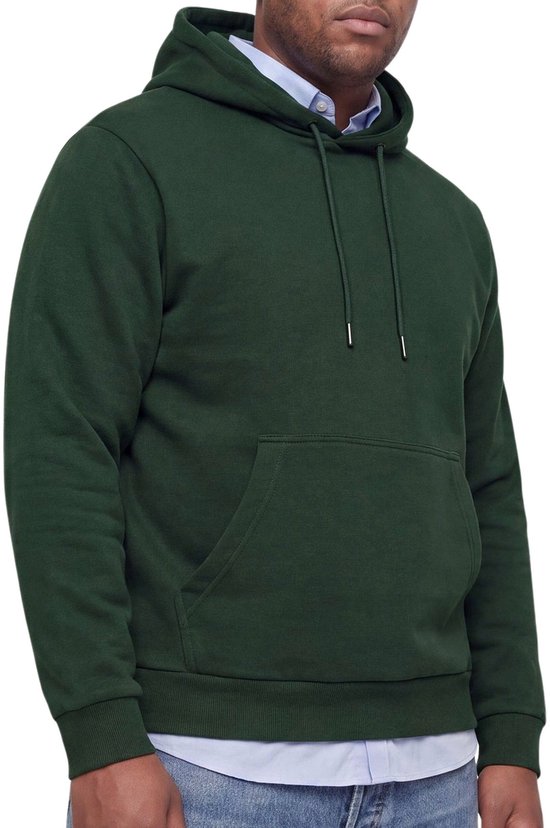 Man van de zijkant in een donkergroene hoodie over een lichtblauw overhemd en jeans.