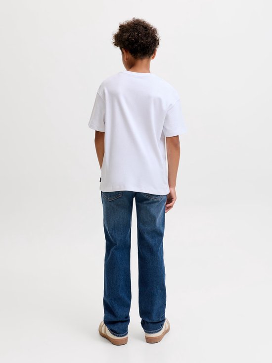 Jongen met witte t-shirt en blauwe jeans, staand vanaf de achterkant.