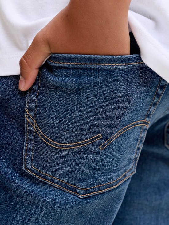Close-up van een blauwe jeans achterzak met bruine stiksels.