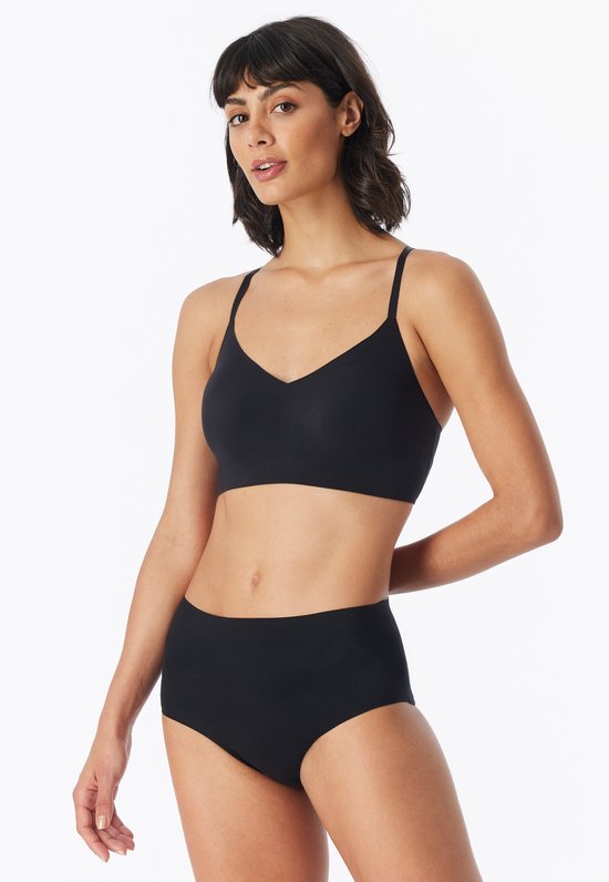 Model draagt een zwarte bustier met V-hals, gecombineerd met hoge bikinislip.