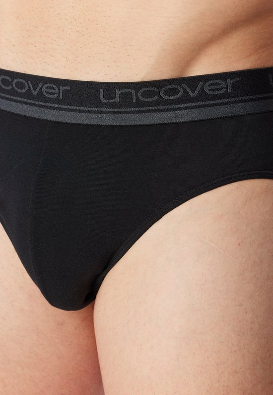 Voorkant van een zwarte slip met grijze band met UNCOVER-logo.