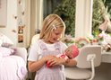 Meisje met staartjes houdt Luvibubs pop vast, pop heeft roze haar, blaadjes op hoofd en pyjama met hartjes.
