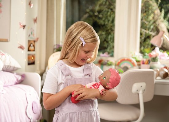 Meisje met staartjes houdt Luvibubs pop vast, pop heeft roze haar, blaadjes op hoofd en pyjama met hartjes.