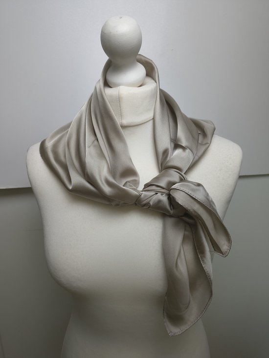 Lichtbruine zijden sjaal geknoopt om een mannequin.