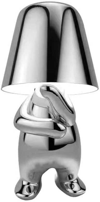 Lampe de bureau argentée et polie en forme de petite figurine avec un abat-jour pour tête.