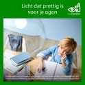 Jongen leest in een notitieboekje bij een bureau, met EyeComfort logo.