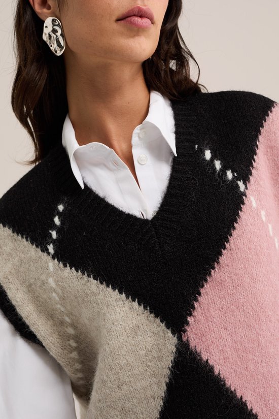 Close-up van gebreide spencer met ruitpatroon in roze, zwart en beige.