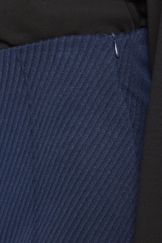 Close-up van de taille van de donkerblauwe broek met een ritssluiting aan de zijkant.
