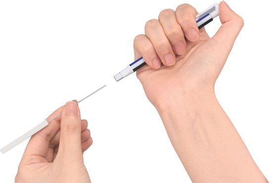 Handen wisselen een witte, rechthoekige gum uit voor een nieuwe in de Tombow Mono zero pen.