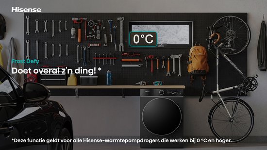 Een zwarte Hisense wasdroger staat in een garage naast een auto en fietsen. Boven de droger hangt een bord met "0°C".