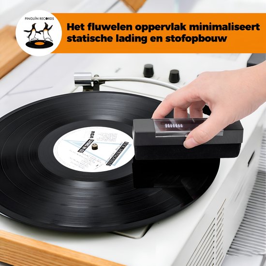 Hand gebruikt de zwarte vinyl borstel op een draaiende LP.