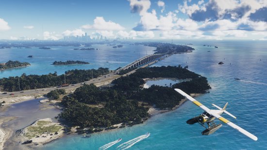 Luchtfoto van een watervliegtuig dat boven een eiland met tropische vegetatie vliegt, met een brug en een stad op de achtergrond.