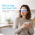 Vrouw met lichttherapiebril, witte bril met blauwe accenten en blauw licht, houdt mok vast.