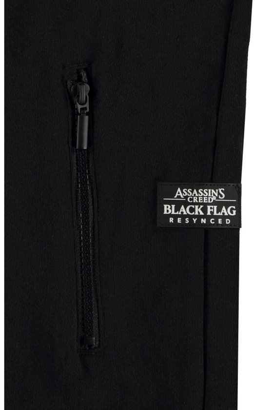 Close-up van een zwarte hoodie met ritszak en een label met "Assassin's Creed Black Flag Resynced".
