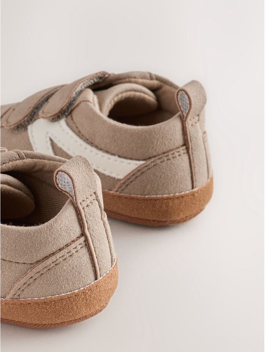 Achterkant van bruine suède babysneakers met witte strepen en klittenbandsluiting.