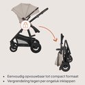 Beige kinderwagen wordt ingeklapt tot een compact formaat. Slot symbool geeft aan dat hij vergrendeld is.