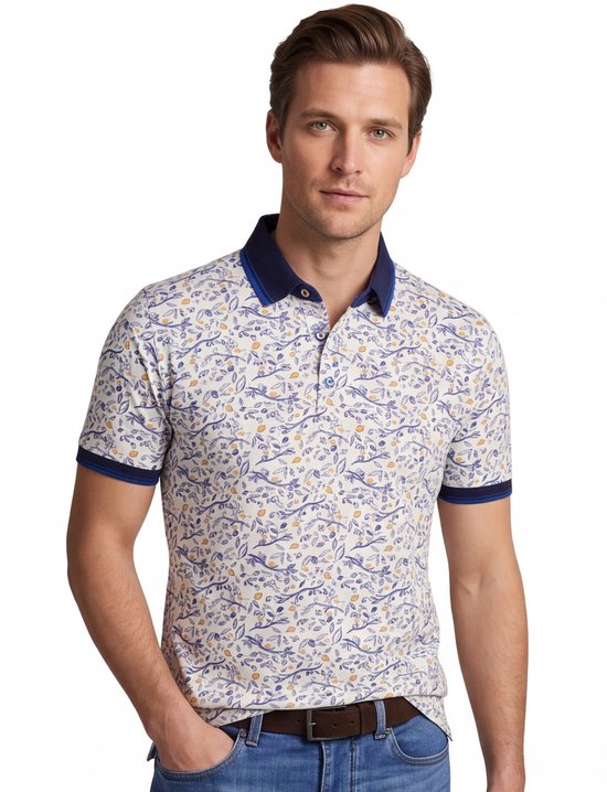 Man met de voorkant naar de camera, draagt een wit poloshirt met een veelkleurig print van blauwe takken, gele vruchten en bladeren. De kraag en mouwen zijn donkerblauw.