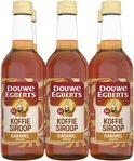 Drie flessen Douwe Egberts Karamel Koffiesiroop, met rood, geel en oranje label en opdruk.