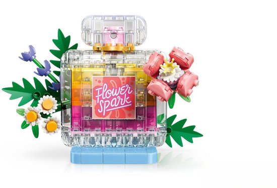 Flacon de parfum transparent avec couches jaunes, oranges et roses, étiquette 'Flower Spark', fleurs roses et petites fleurs violettes.