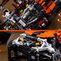 Gedetailleerd interieur van een zwarte en oranje LEGO-auto met zichtbare motoronderdelen.