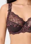 Detailopname van een bruine beugelbeha met kanten afwerking en roze accenten bij de halslijn.