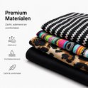 Gestapelde stoffen voor hoofdbanden: zwart met witte zigzag, zwart met kleurrijke horizontale strepen, luipaardprint, en effen zwart.