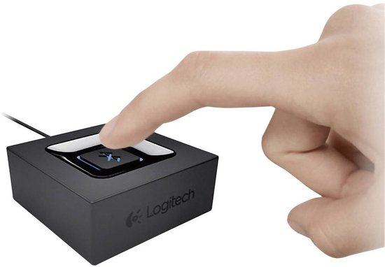 Een hand drukt op het blauw verlichte Bluetooth-logo van een zwarte Logitech adapter.