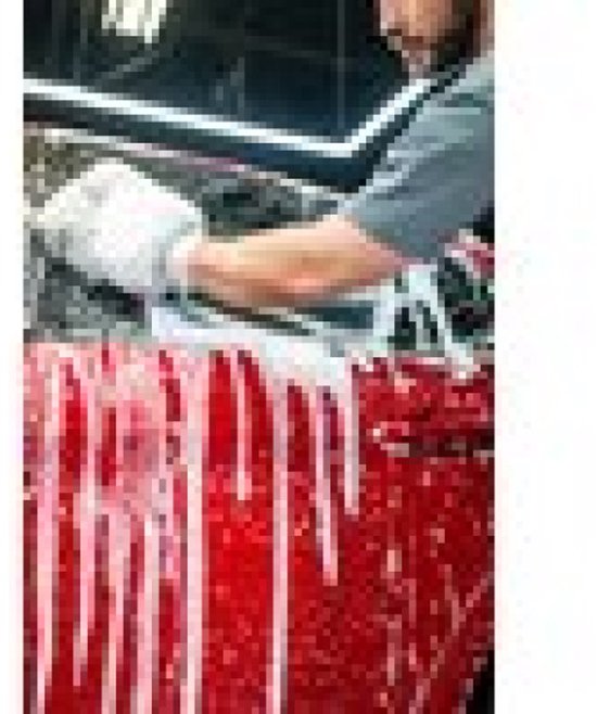Man wast een rode auto met schuimend autoshampoo.

