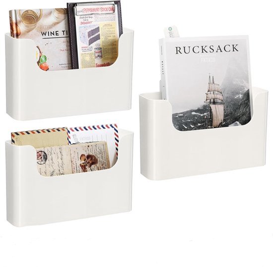 Drie witte wandgemonteerde opbergvakken met tijdschriften, enveloppen en een boek.