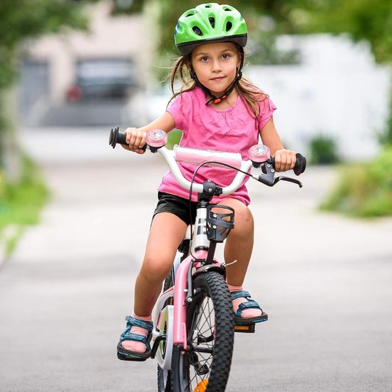 Meisje met een roze fietsbel met eenhoorn op een roze fiets met een groene helm.