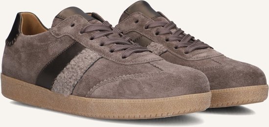 Grijze suède sneakers met een donkerbruine en beige opgestikte streep, vetersluiting en bruine zool.