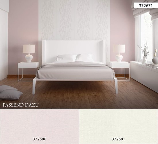Een wit bed met grijze lakens en gele lampen staat in een slaapkamer met een roze en creme gestreepte muur en verticaal bloesemdessin.