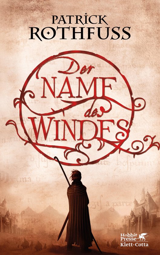 Boekomslag met de titel 'Der Name des Windes' in rode letters binnen een cirkelvormig ornament. Een figuur met een staf staat op de voorgrond.