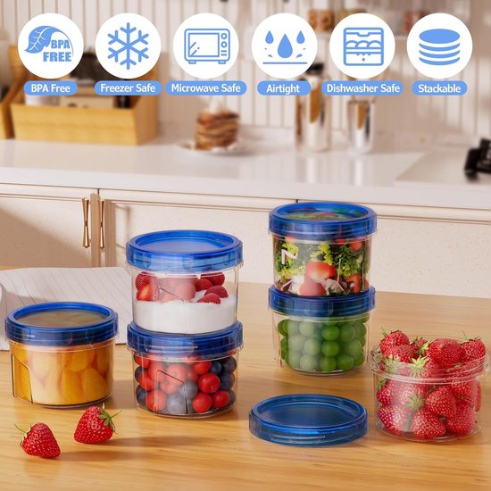 Boîtes de conservation transparentes avec couvercles bleus, remplies de fraises, fraises à la crème, myrtilles, légumes et fruits.