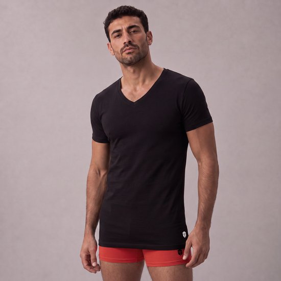 Zwart slim fit V-hals T-shirt van bamboe, gedragen door een man met oranje ondergoed.
