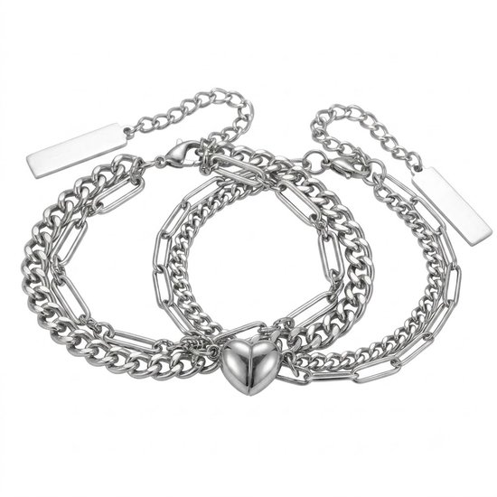 Twee zilverkleurige schakelarmbanden, elk met een dubbele ketting en een rechthoekig bedeltje aan de zijkant. Beide armbanden hebben een magnetische hartvormige sluiting in het midden.