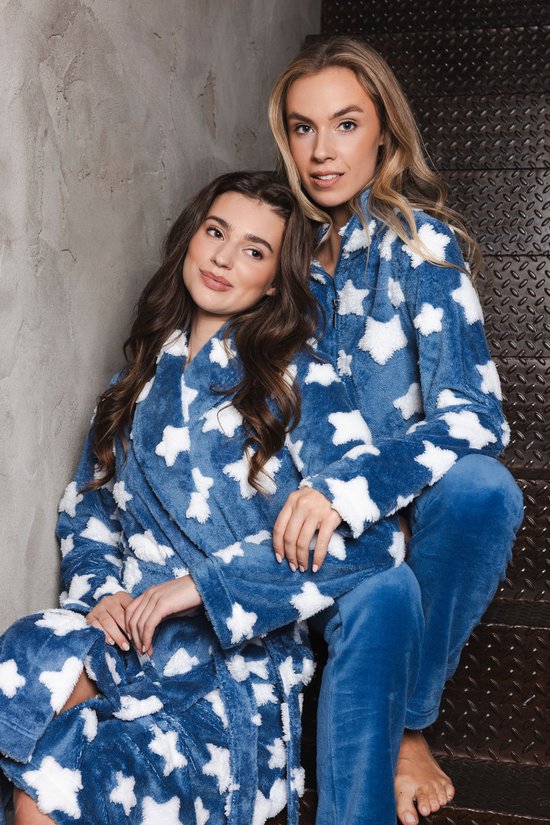 Twee modellen in blauwe badjassen met witte sterren, zittend op een trap.