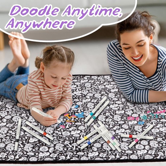 Een vrouw en een jong kind liggen op een zwart-wit deken met een paddenstoel- en bloemenprint en kleuren deze met stiften.