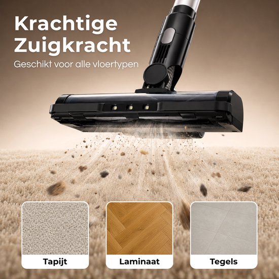 Close-up van een zwarte steelstofzuigerkop die vuil opzuigt van een beige tapijt, laminaat en tegels. "Krachtige Zuigkracht Geschikt voor alle vloertypen".