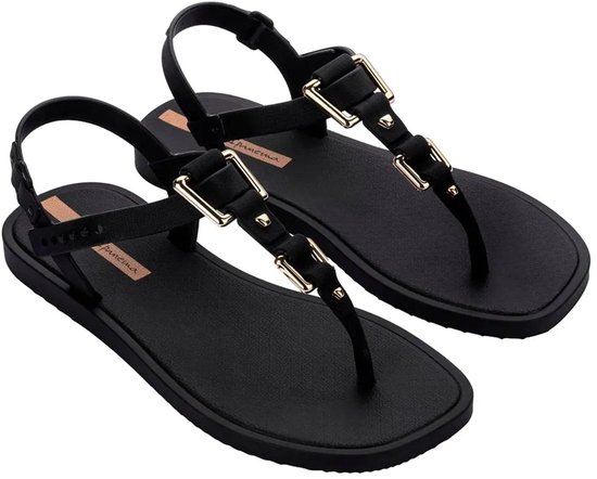 Zwarte Ipanema slippers met gouden gespen, deels van voren gezien.