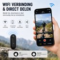 Hand die een smartphone vasthoudt met een WINNES sportcamera ernaast, beeld van een fietser.