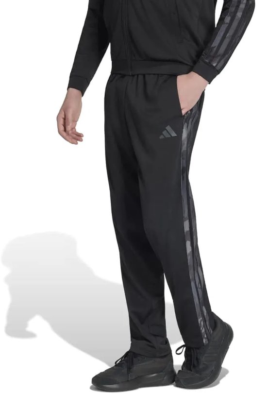 Zwarte trainingsbroek met camouflage Adidas-strepen op de zijkant en een Adidas-logo op de linker dij.