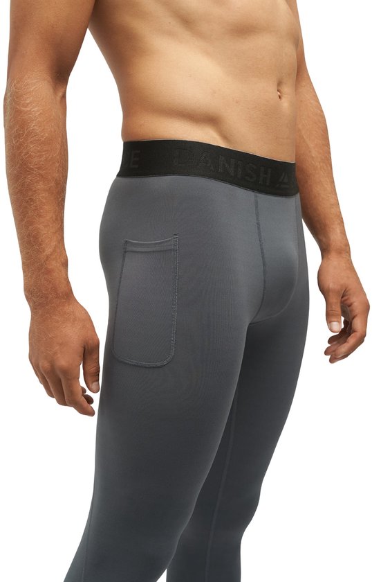 Man in grijze compressietights met een steekzak en merklogo op de tailleband.