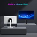 Twee moderne, strakke monitoren op grijze sokkels. De achterkant van een witte monitor met een gebogen, zwarte hals is zichtbaar, naast een zwarte monitor.