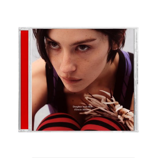 CD-hoes met een close-up van Gracie Abrams met kort donker haar en streepjeskousen.