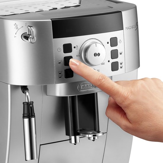 Een vinger drukt op de knop voor het instellen van de maalgraad van de zilveren De'Longhi Magnifica S espressomachine.