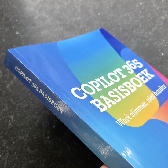 Livre avec couverture bleue, titré 'COPILOT 365 BASISBOEK' et 'Travaillez plus intelligemment, pas plus dur'.